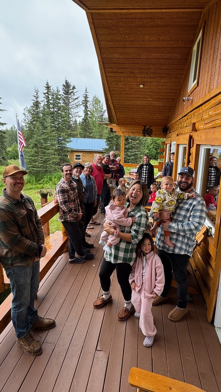Extended family gathered on the lodge porch with the youngest kids in front