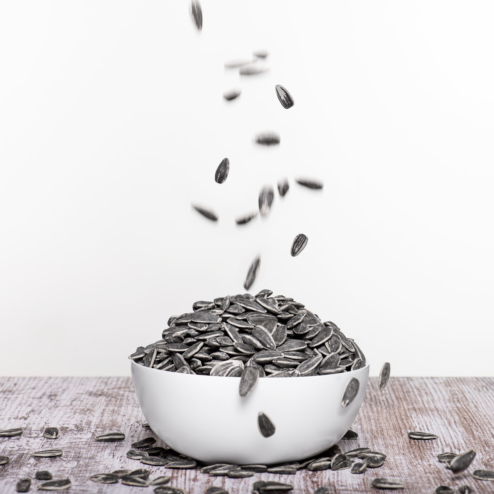 Sunflower seeds falling into a bowl — Jumbo